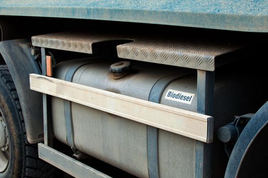 Closeup of a biodiesel tank of a large excavation truck covered with dirt