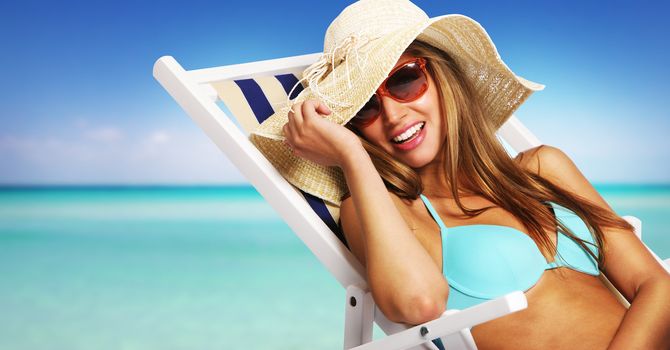 Smiling young woman relaxing on beach chair