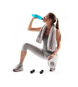 Thirsty young woman drinking after fitness workout