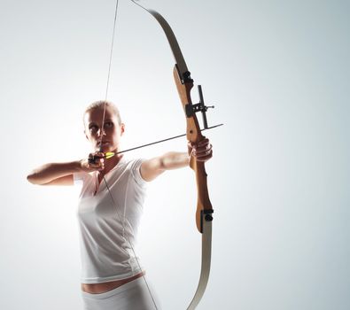 Beautiful woman aiming with bow and arrow