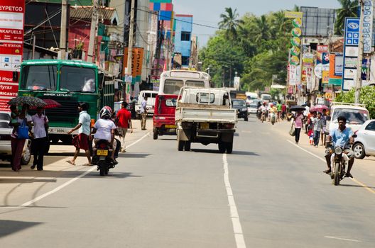 Matara, Sri Lanka - December 10, 2011: Intensive traffic on a narrow asian street with pedestrians, motobikes and cars.