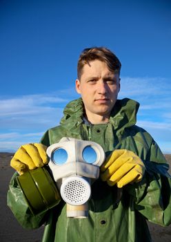 A man in a overalls with a mask in his hands