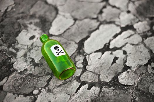 Bottle with the poison lying on poisoned ground