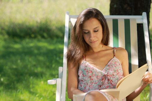 Young woman reading a book at park