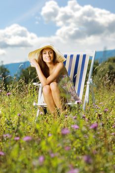 Young beatiful woman relaxing on a field of flowers
