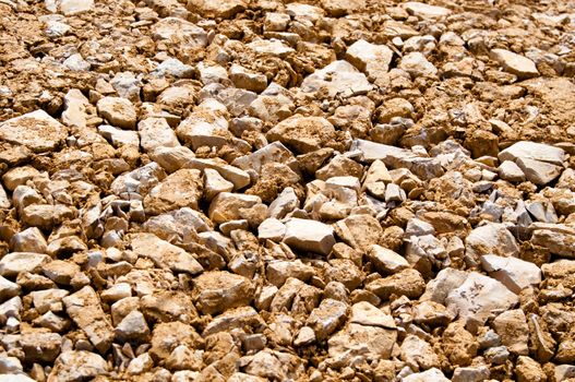 Brown construction site gravel background - the large stones are flattened by heavy machinery