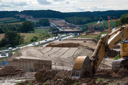 ZUSMARSHAUSEN, GERMANY – JULY 15: Construction site of the extension of A8 highway from currently 4 to 6 lanes at Zusmarshausen, Germany on July 15, 2012. Heavy machinery is used for this massive project happening in a timeframe of over 2 years.