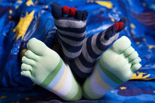 Stock photo: an image of two pairs of funny feet in striped socks