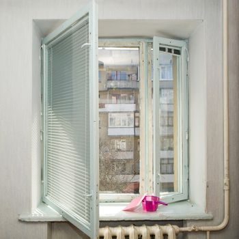 An image of an open window and jug with sponge on it