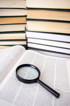 An image of magnifier and books