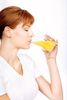Pretty handsome woman dressed in white shirt drinking orange juice
