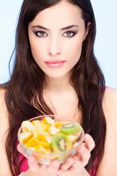 Pretty brunette holding bowl full of fruit