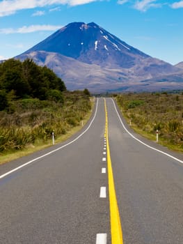 Straight highway leading to active volcano cone of Mount Ngauruhoe in Tongariro National Park, North Island of New Zealand