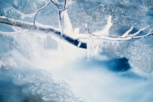 Splashing water of small creek forming beautiful icicles during freeze-up.