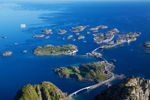 Scenic town of Henningsvaer on Lofoten islands in Norway with large fishing harbour and bridges connecting rocky islands
