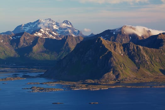Mountains and fjords on Lofoten islands in Norway lit by midnight sun in early summer