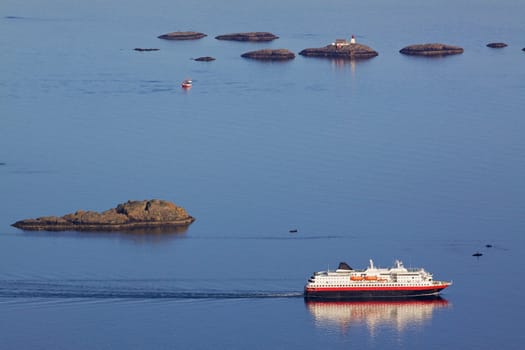 Large passanger ship sailing along scenic norwegian coast