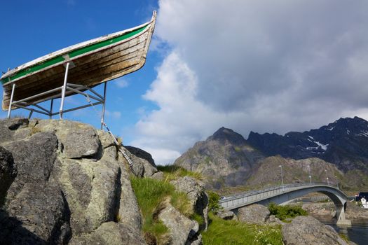 Bridge leading to town Henningsvaer on Lofoten islands with old fishing boat