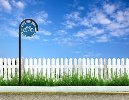 bicycle sign and white fence and blue sky