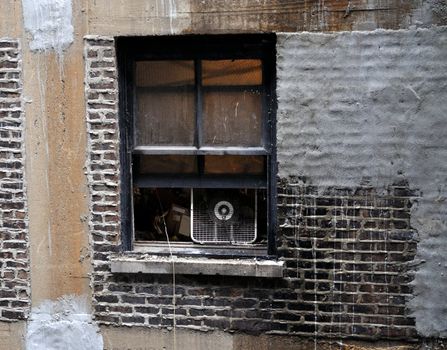 Open window in an old, rundown apartment building.