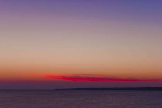 purple sunset and calm water of the sea