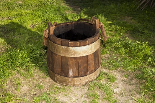 old wooden bucket on the grass background