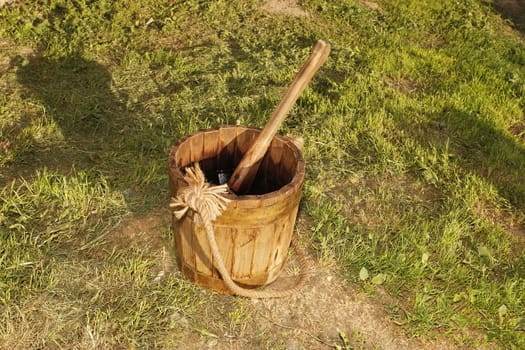 old wooden bucket on the grass background