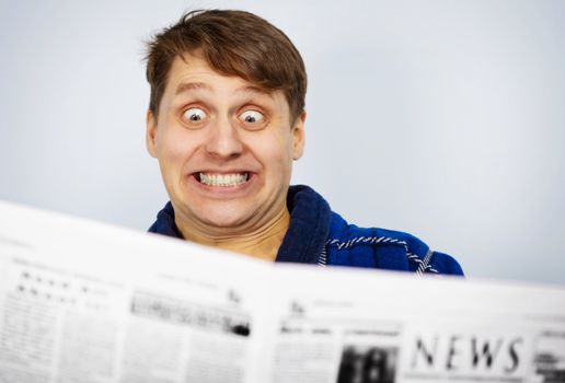 Man shocked while reading the news from newspapers