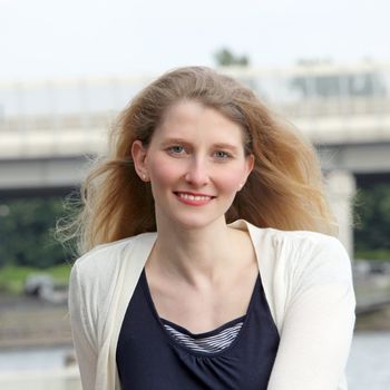 Attractive smiling middle-aged woman standing outdoors looking directly at the camera 