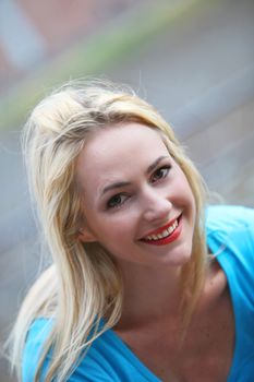 High angle close up portrait of a smiling blonde woman outdoors in sunshine High angle close up portrait of a smiling blonde woman outdoors in sunshine