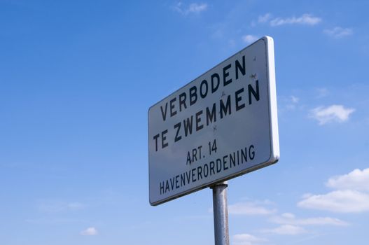 wit bord met verboden te zwemmen volgens de havenverordening
