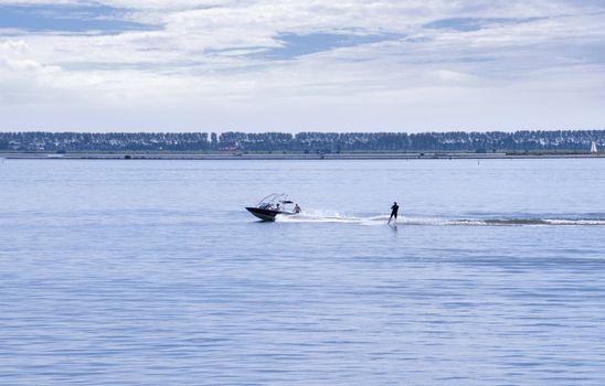 people in the boat and water ski behind it on the haringvliet in Holland