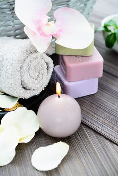 Spa and wellness setting with natural soap, candles and towel. Beige dayspa