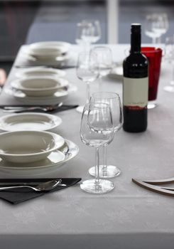 Casual table setting with cutlery, plates and wine glasses