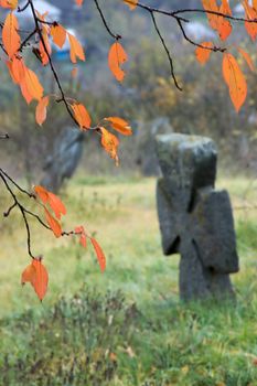 A stone cross on an autumn graveyard