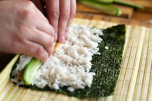 An image of man making california roll close-up