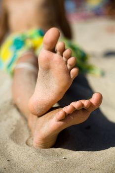 An image of little feet on the sand