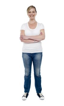 Casual aged woman posing with crossed arms standing over white background