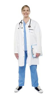 Full length portrait of smiling senior female doctor holding clipboard isolated over white