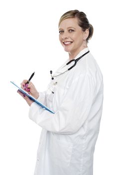 Smiling aged surgeon holding pen and clipboard and looking at camera