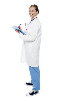 Side view portrait of experienced female physician writing patients report