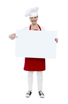 Experienced cook indicating at blank white banner, full length portrait