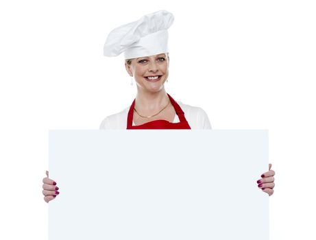 Happy matured cook presenting blank billboard against white background