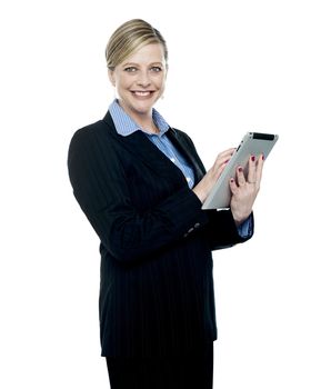 Smiling corporate woman using wireless tablet pc facing camera