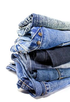 stack of blue denim jeans on white background