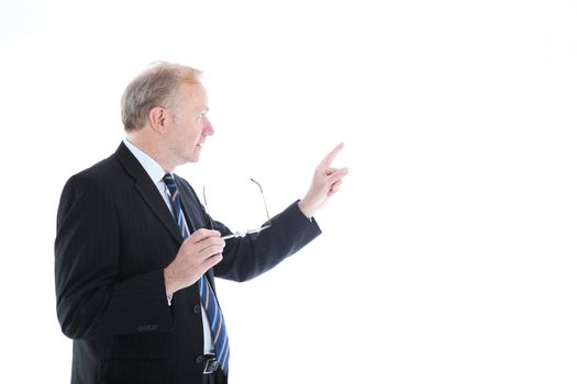 Businessman looking back away from the camera and pointing with his index finger to blank copyspace