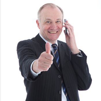 Smiling buisness man on a mobile giving a thumbs up of victory and success isolated on white Smiling buisness man on a mobile giving a thumbs up of victory and success 