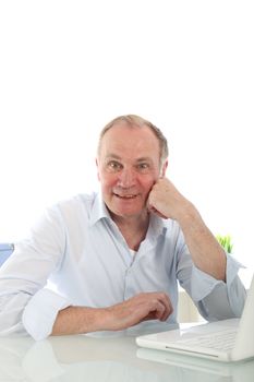 Interested enthusiastic businessman leaning on his desk looking at he camera with an alert expression 