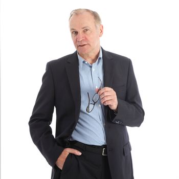 Stylish charismatic middle-aged businessman standing listening with his glasses in his hand isolated on white 