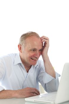 Excited middle-aged man reading his laptop screen while seated at his desk 